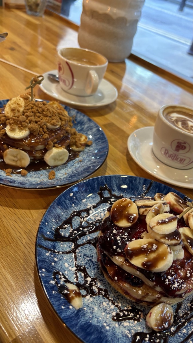 Biscoff and banana pancakes with coffees on the window bench at Neama